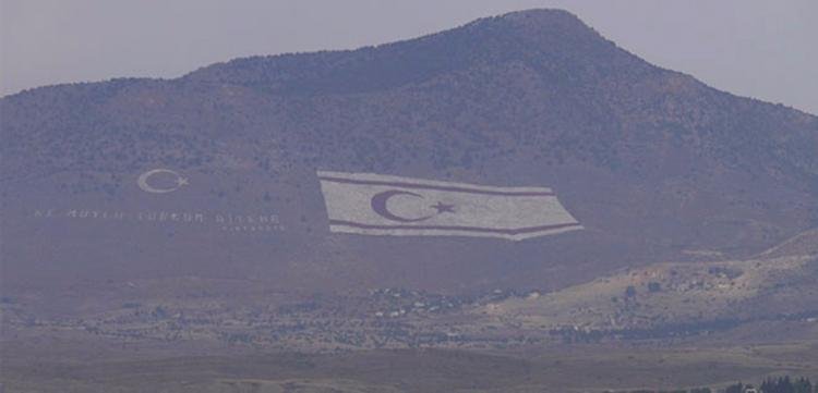 Kürdistan dağlarına çizdiği devasa bayraklarla işgalini “inandırıcı” kılmaya çalışmasıyla tanıdığımız Türk devlet mantığı, Kıbrıs’ta da huyundan vazgeçmiyor elbette. Fotoğrafta görülen Beşparmak Dağları üzerindeki bayrak ve “Ne mutlu Türk’üm diyene” yazısı, Kıbrıslı Rumların her gün işe giderken görebileceği biçimde kurgulanmış... İşgalcinin ‘aşağılık kompleksi’ öyle güçlü ki üstelik, bayrakların dibindeki köyde elektrikler kesilse bile bayrağı aydınlatan ışık hiç sönmüyor!